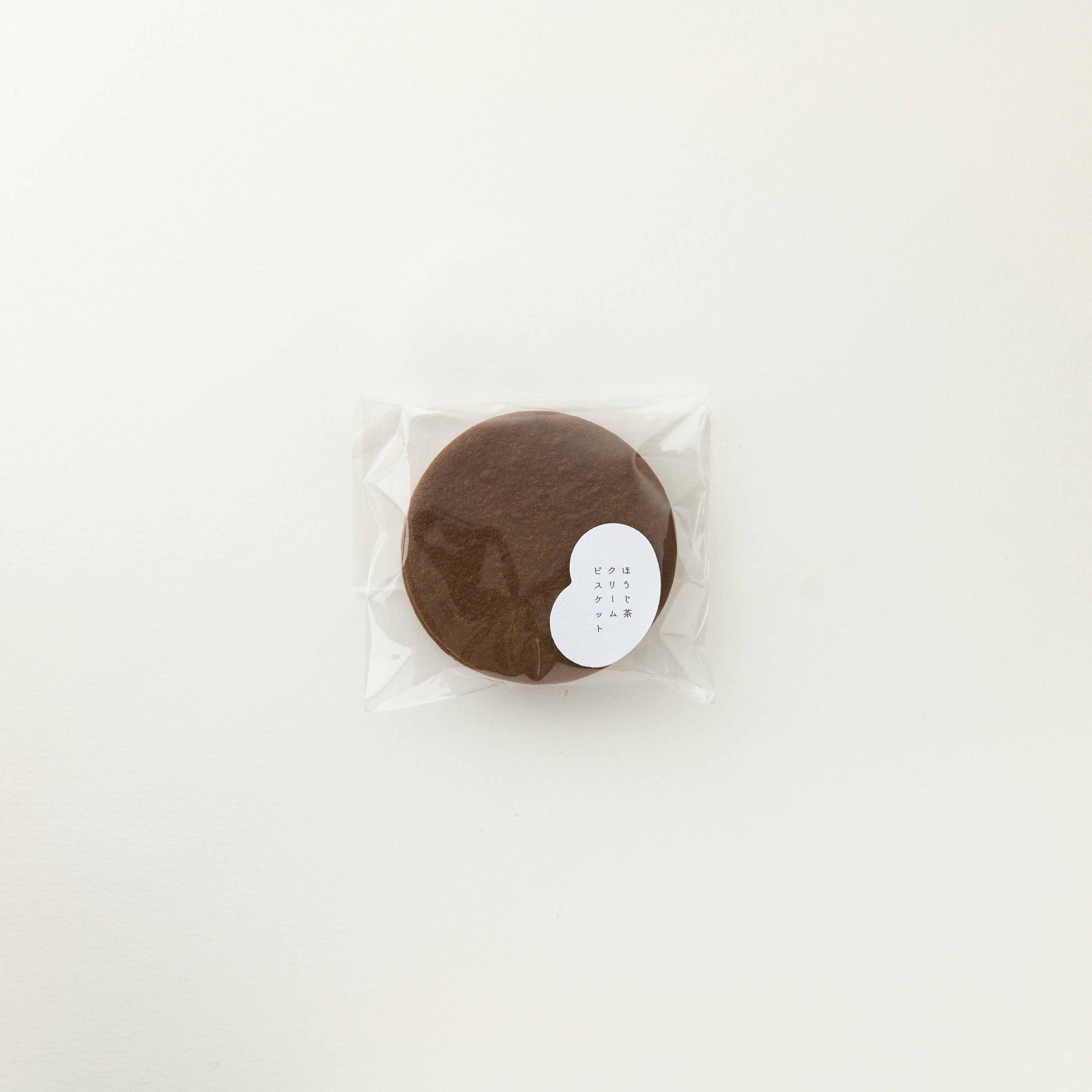 Round brown product in clear packaging on a white background