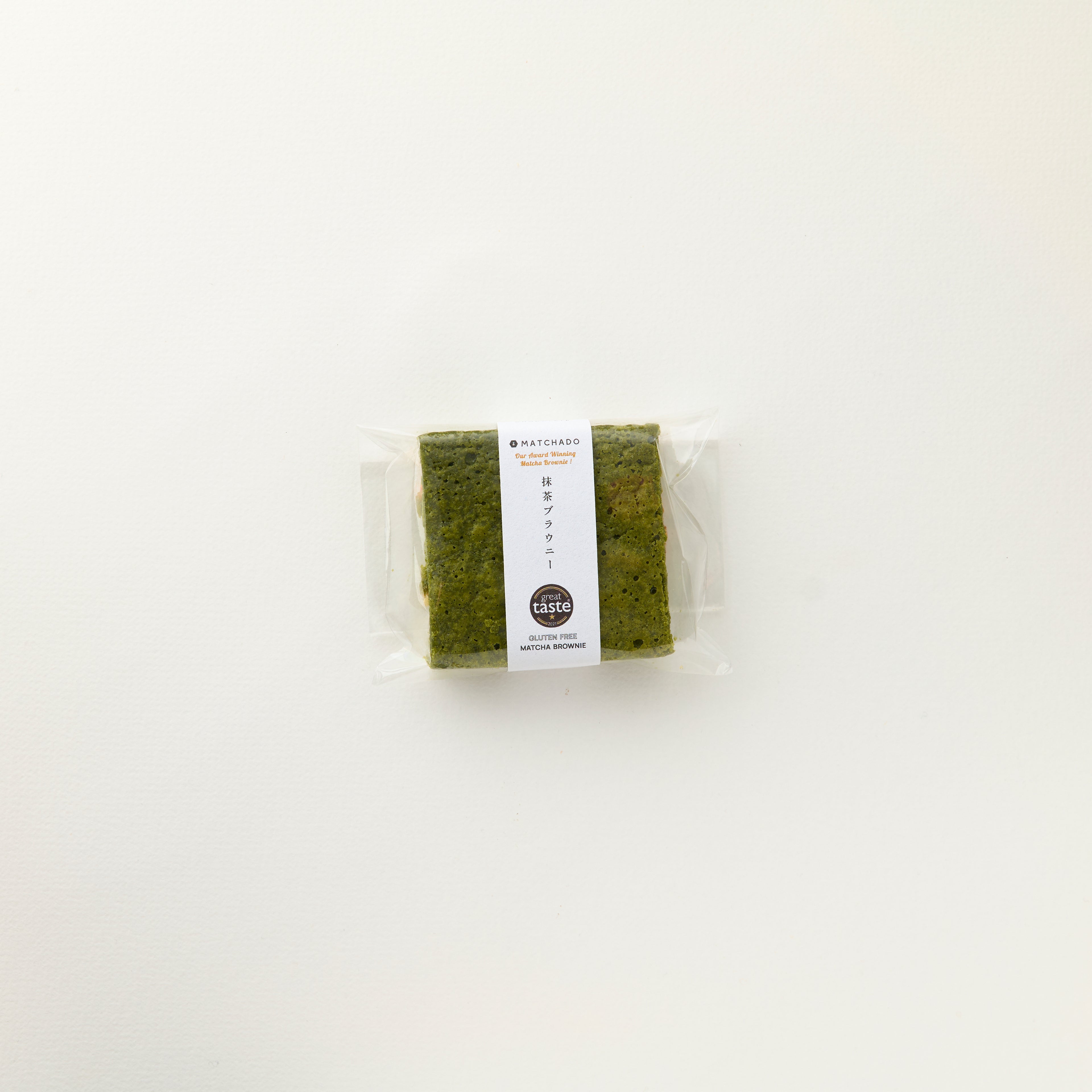 MATCHADO Gluten-Free Matcha Brownie – White Chocolate Great Taste Award Winner. Packaged green tea on a white background