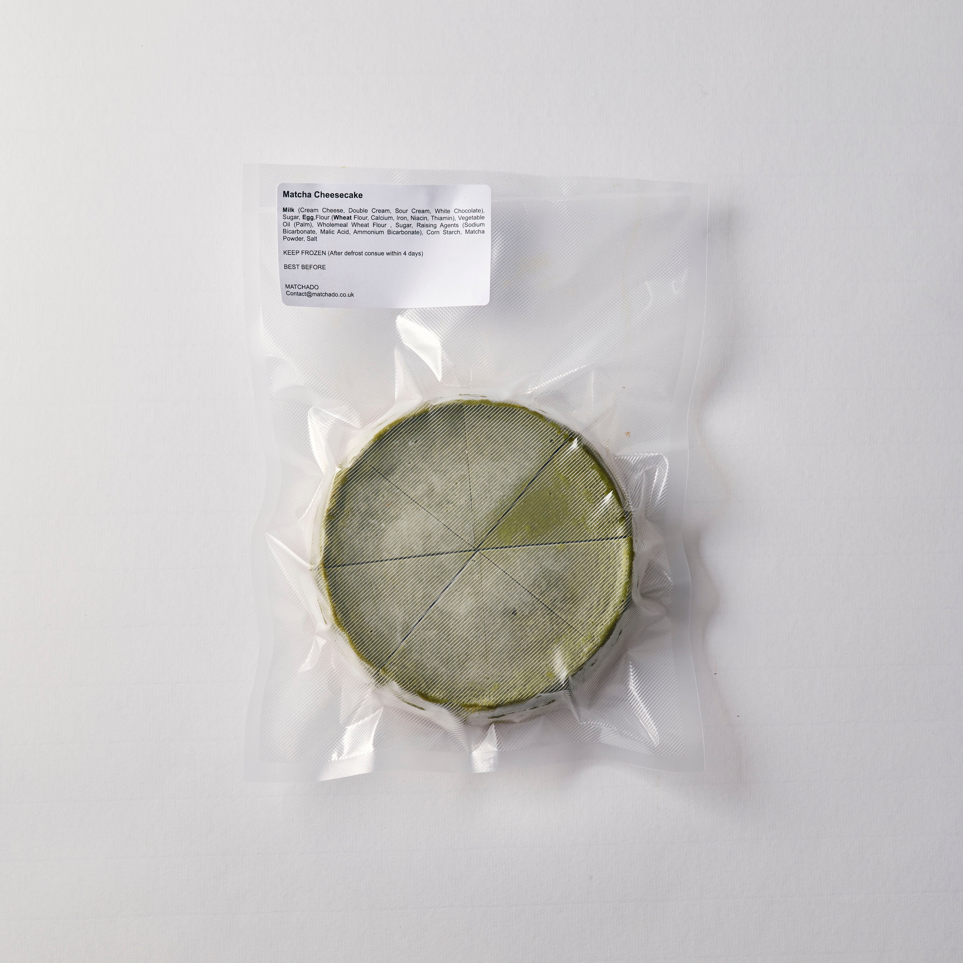 Matcha cheese wheel in clear plastic packaging on a white background
