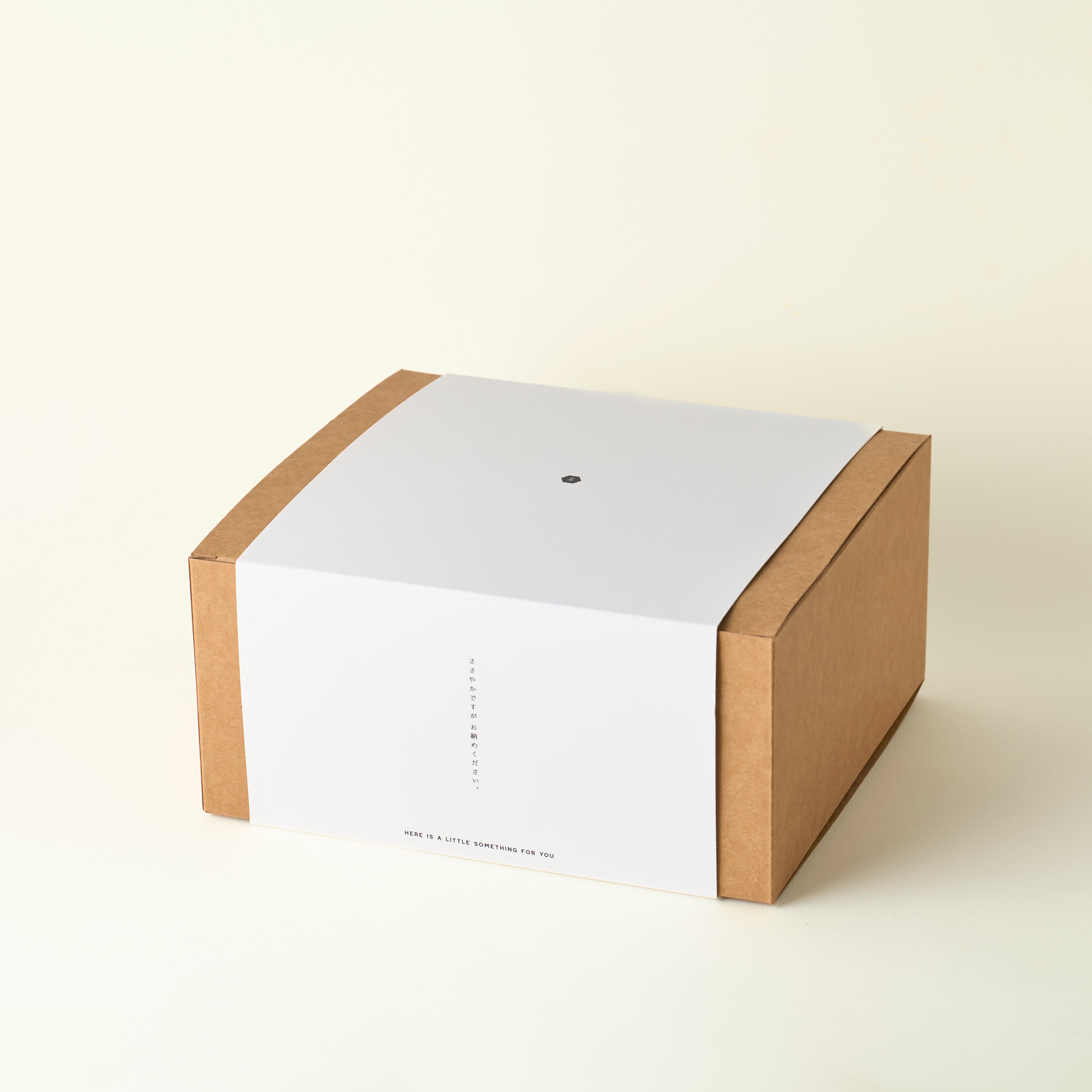 White box with a brown cardboard base on a beige background