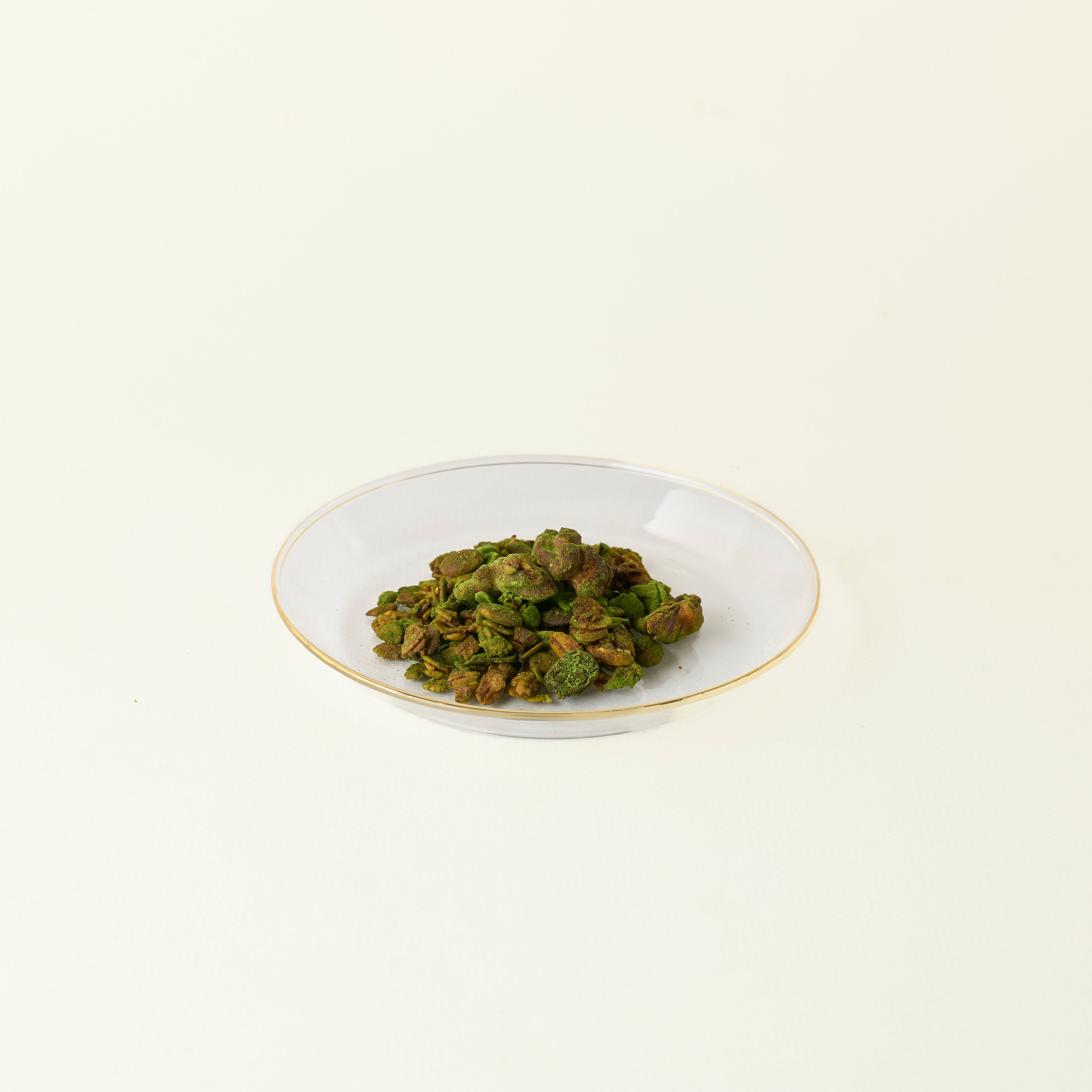 White bowl with MATCHADO matcha granola on a beige background