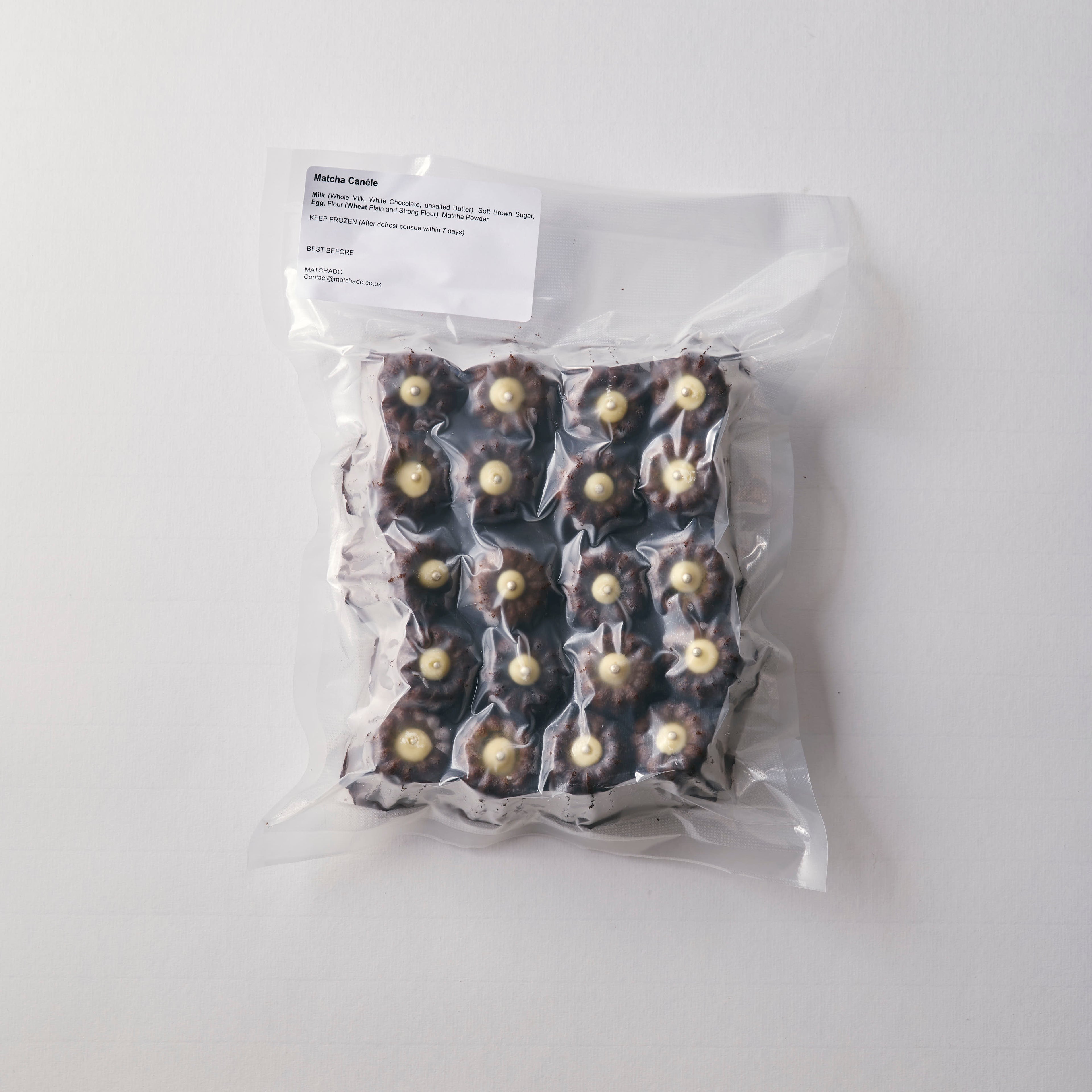 Wholesale pack of MATCHADO Matcha Canelés in vacuum-sealed packaging. This 20-piece pack shows the canelés topped with matcha cream, securely sealed for freshness.
