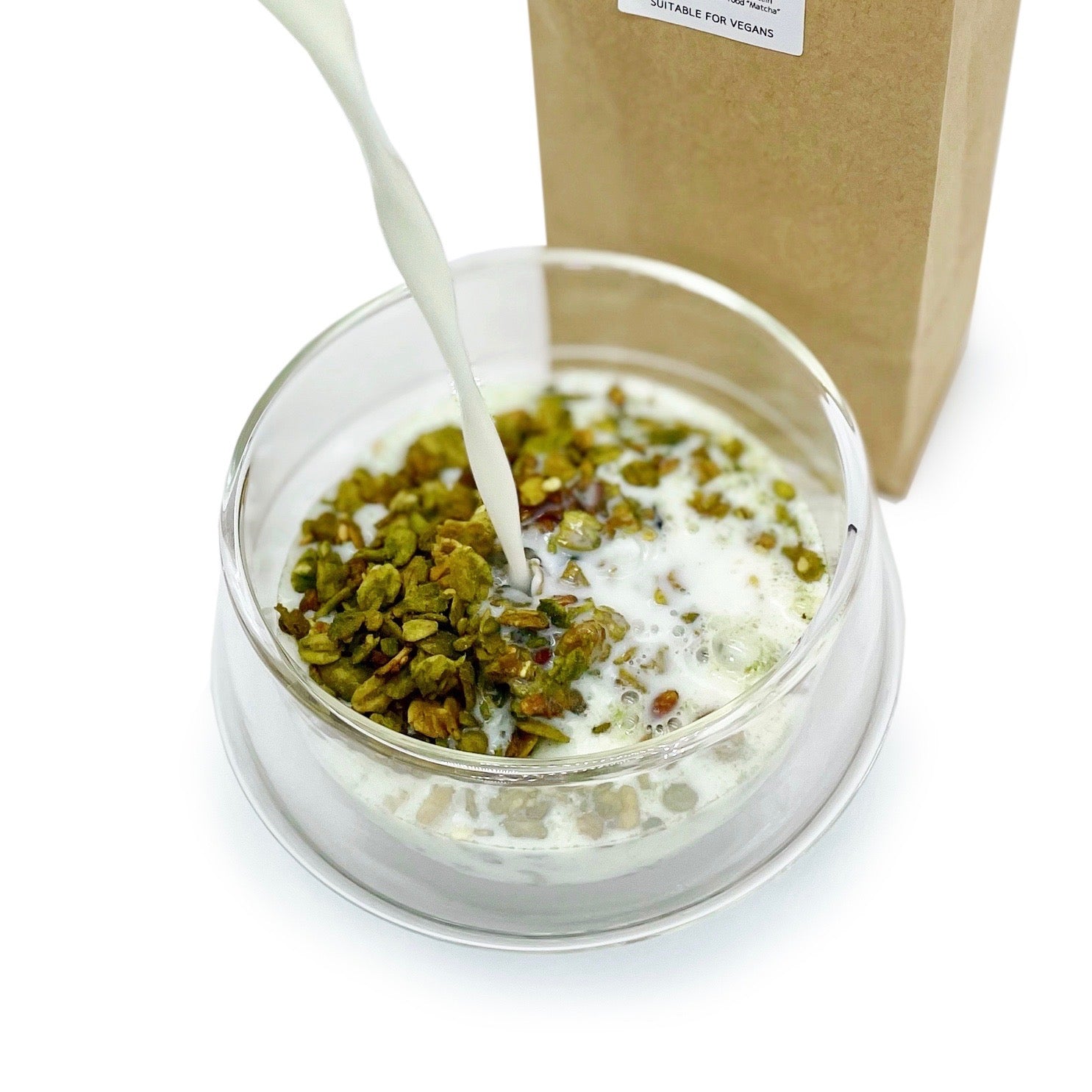 Glass bowl with MATCHADO matcha granola and pouring milk