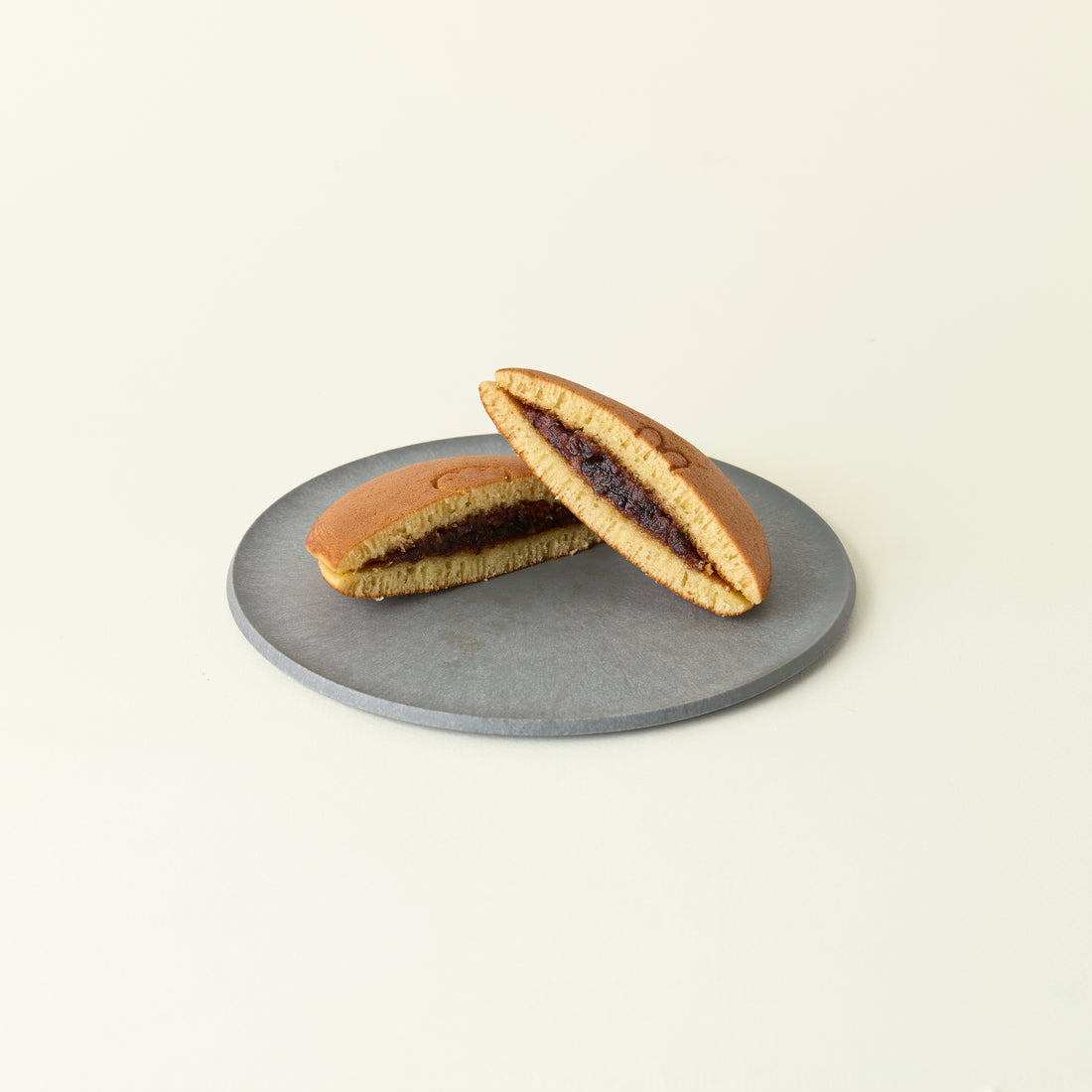 MATCHADO Miffy Anko Red Bean Dorayaki - Japanese Pancake - Fluffy &amp; Sweet Handmade Treat. Two halves of a sandwich cookie on a gray plate with a beige background