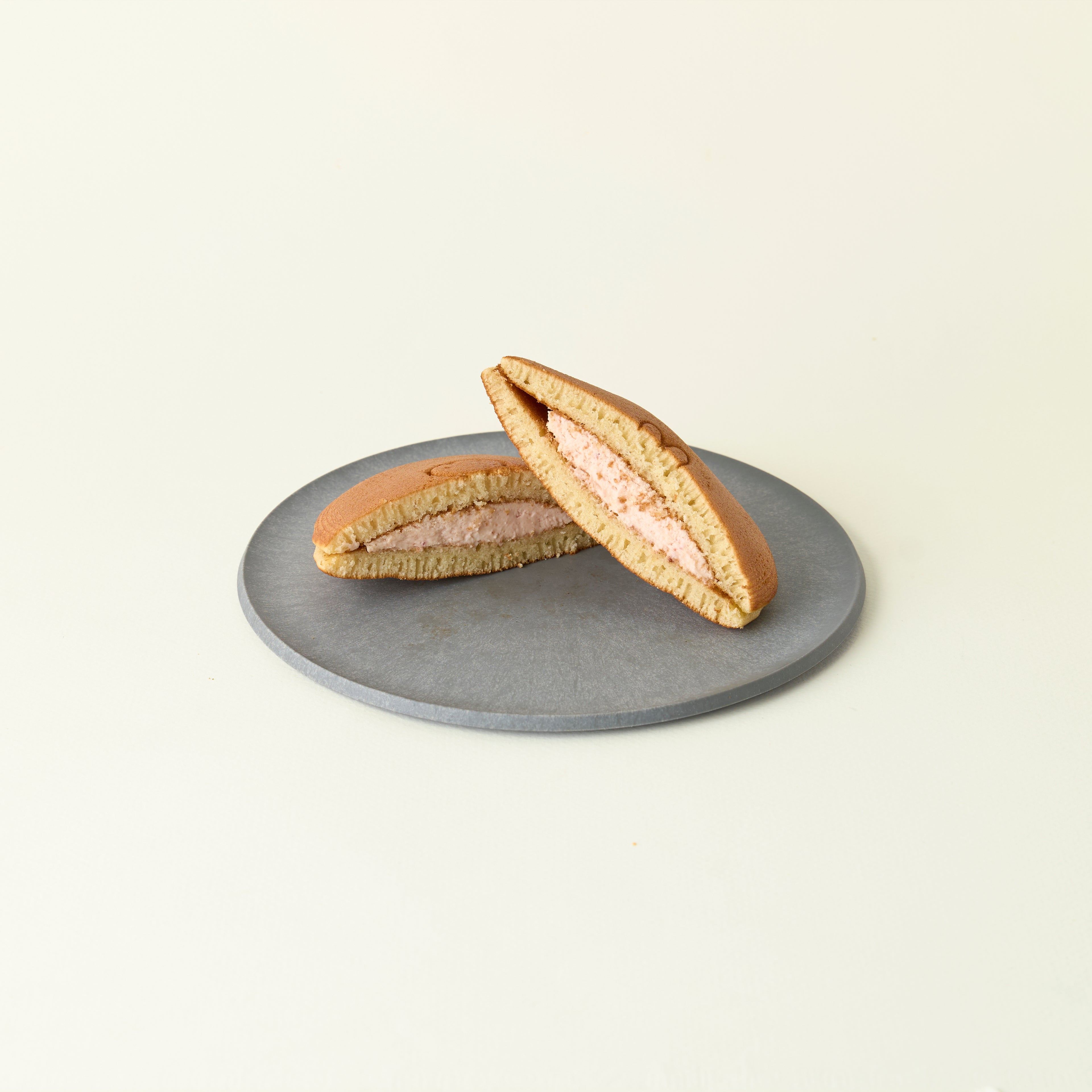 Two halves of a dorayaki on a gray plate against a light beige background
