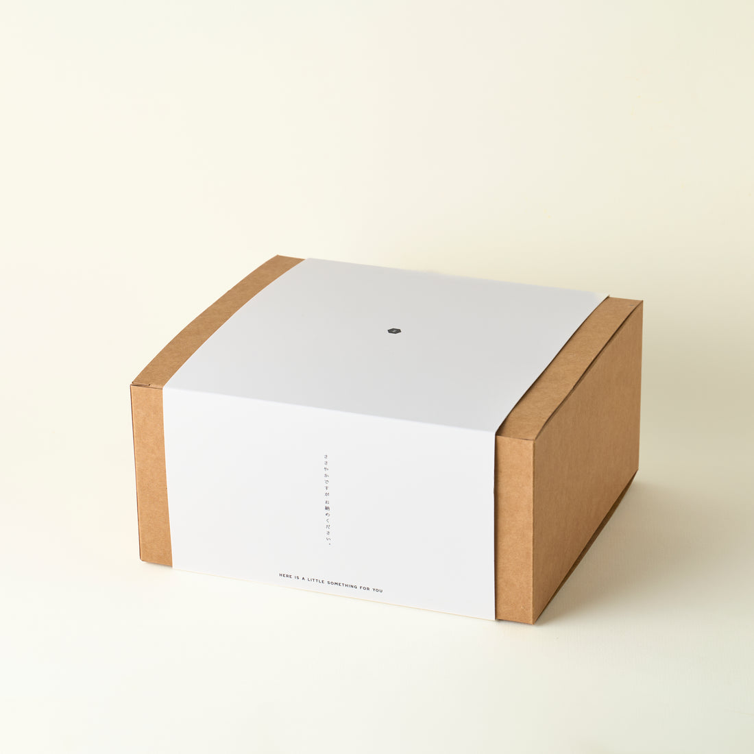 White box with a brown cardboard base on a beige background