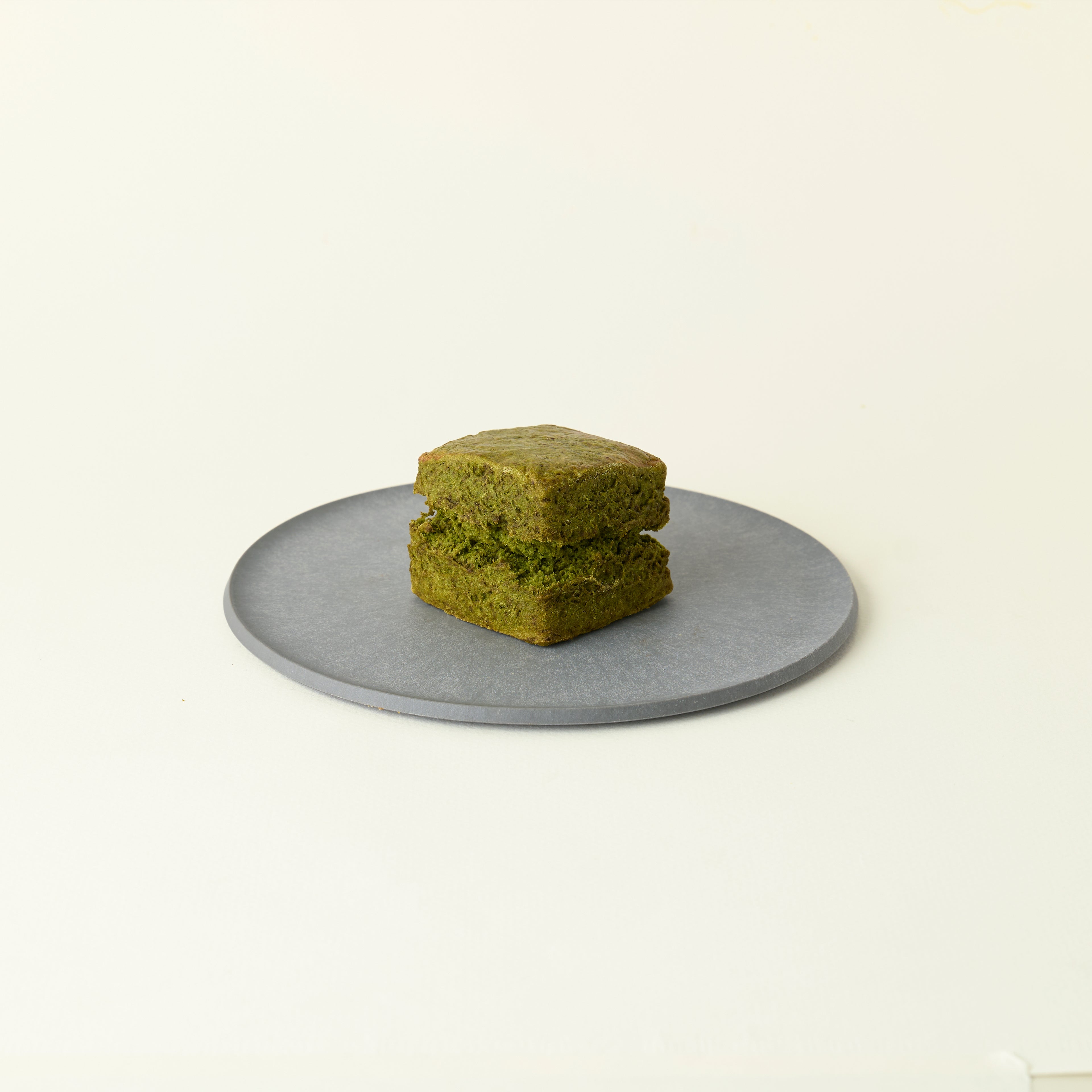 MATCHADO Matcha Scones. A scone on a round metallic plate with a white background