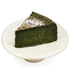 A gift set featuring a whole MATCHADO Matcha Gâteau Chocolat and a sleek silver cake server. A sliced piece of the cake is shown to display its rich texture.